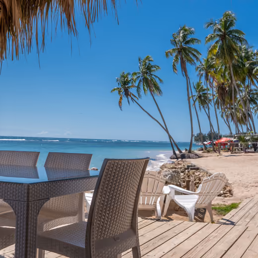 Terraza de madera con mesas frente a la playa